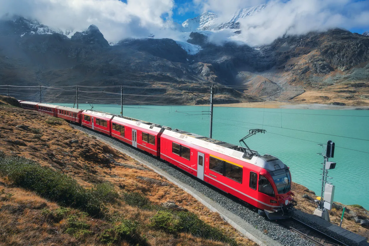 red-train-is-moving-along-railway-in-swiss-alps-mo-2025-03-18-21-28-42-utc2.webp